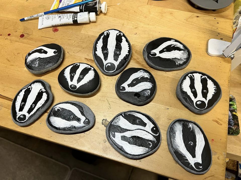 Bench covered in stones which have badger's heads painted onto them