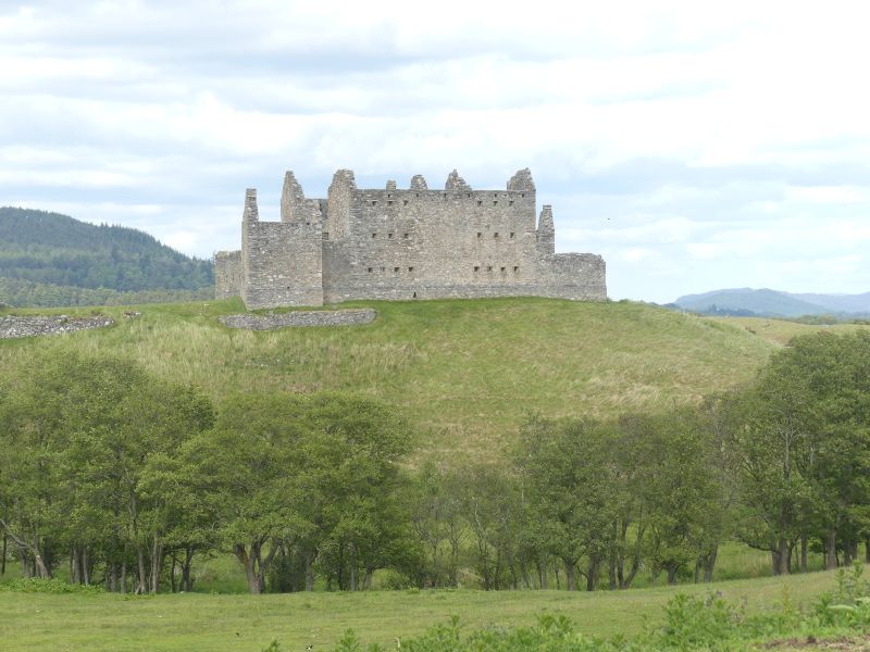 Large old building on top of a grassy hill