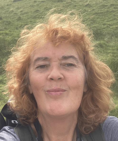 Head and shoulders selfie of a woman with long curly hair